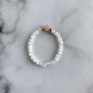 Close-up of beaded ring with white crystal beads and a center lavender gemstone