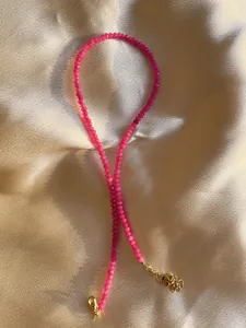 Detail of pink faceted natural stone beads on a 18k gold plated stainless steel chain