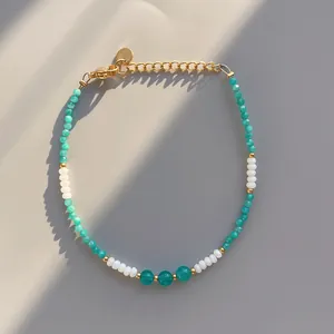 Detail of beaded bracelet with turquoise stones, gold clasp, and adjustable extender chain