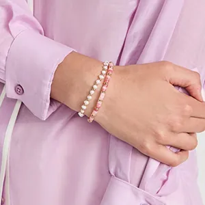 Detalle de pulseras de cuentas con perlas blancas y piedras con textura de mármol rosa