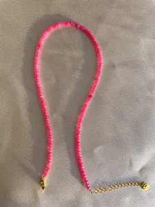 Close-up of pink faceted beaded necklace with adjustable gold-plated extension chain