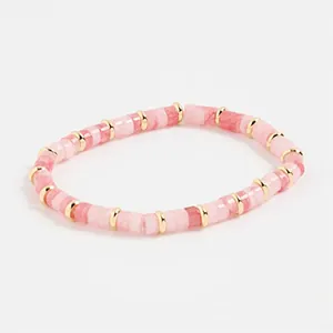 Detalle de cuentas cilíndricas rosa y blanco con espaciadores dorados en la pulsera