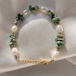 Détail de bracelet en perles d'eau douce avec pierres vertes et billes dorées