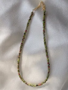 Detailed macro view of handmade colorful natural stone beads with gold plated chain