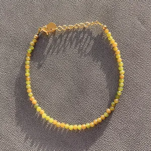 Vue détaillée des perles de pierre naturelle et du fermoir mousqueton doré ajustable
