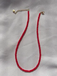 Detail of red faceted natural stone beads and 18k gold plated lobster clasp on necklace