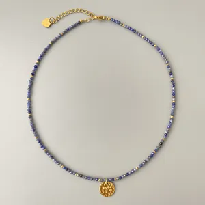 Detalle de collar de piedras azules con colgante de sol dorado y cadena de extensión