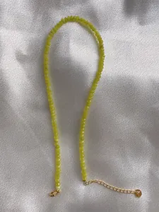 Detail of beaded necklace with light green faceted beads and 18k gold lobster clasp