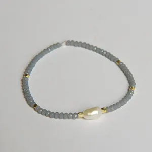 Détail de perle baroque avec perles en cristal gris et accents dorés sur le bracelet