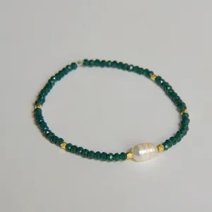 Détail macro d'une perle d'eau douce naturelle et bracelet de perles en cristal facetté vert