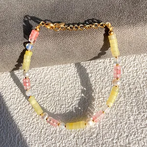 Détail d'un bracelet bohème avec des pierres jaunes et des perles d'eau douce