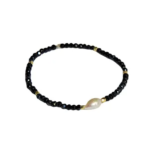 Bracelet élégant en perles noires facettées avec une perle de culture baroque centrale