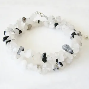 Détail d'un collier double épaisseur avec pierres naturelles blanches et noires sur marbre