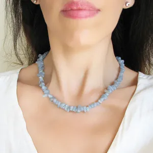 Détail d'un collier en pierres naturelles bleu clair sur mannequin pour style plage