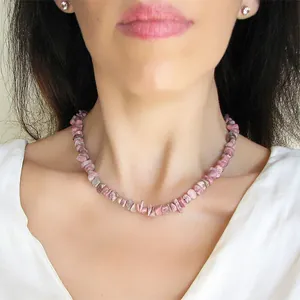 Gros plan du collier en perles de pierre rose irrégulières fait main porté par un mannequin