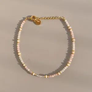 Detail of beaded bracelet with pink and white faceted natural stones and gold lobster clasp