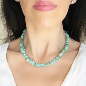 Détail du collier artisanal en pierres naturelles turquoise sur le cou d'un mannequin