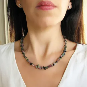 Gros plan d'un collier artisanal en pierres naturelles irrégulières sur un mannequin