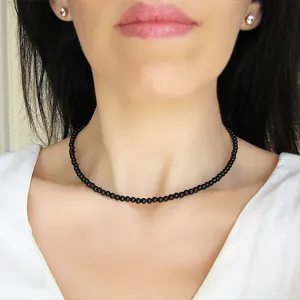 Primo piano di un girocollo fatto a mano con perline nere da 2-3mm su una modella