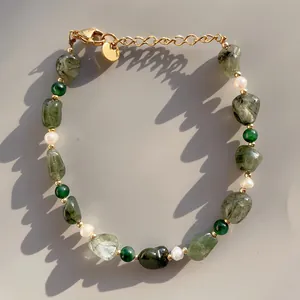 Vue détaillée de pierres naturelles vertes et perles d'eau douce sur un bracelet doré