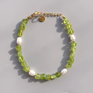 Détail du bracelet en pierres vert olive et perles avec fermoir doré poli