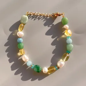 Détail macro de pierres naturelles colorées et de perles d'eau douce sur le bracelet