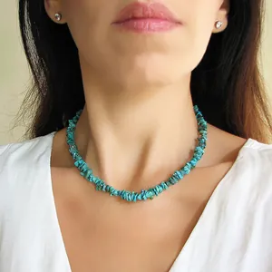 Détail d'un collier de perles en pierres colorées porté par un mannequin en col V