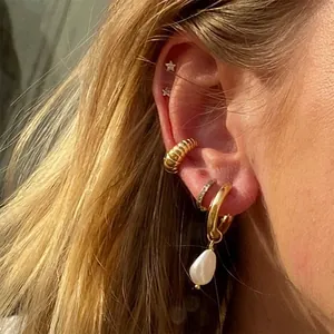 Gros plan d'un ensemble de boucles d'oreilles perles baroques et étoiles sur un mannequin