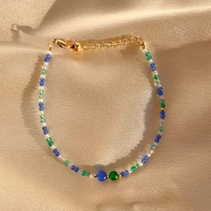Macro shot of colorful spinel beaded bracelet on satin with a gold lobster clasp