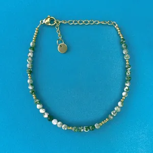 Detail of beaded bracelet with green turquoise stones and gold lobster clasp closure