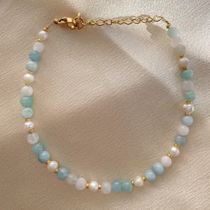 Détail du bracelet perlé avec pierres précieuses bleues, perles et fermoir doré