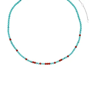 Dettaglio collana bohémien di perline turchesi con accenti di pietra naturale rossa