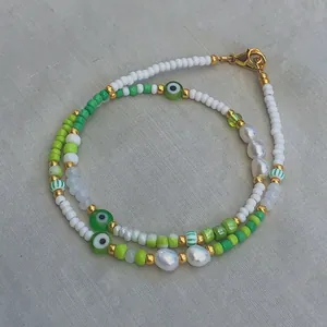 Handmade evil eye necklace with green beads, natural pearls and gold lobster clasp