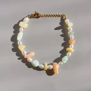 Détail du bracelet en perles et pierres colorées avec fermoir mousqueton doré et chaîne