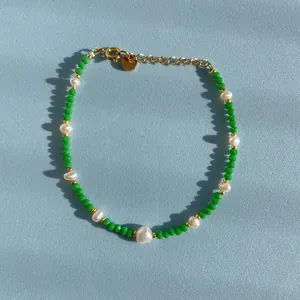 Gros plan sur des perles de cristal vert et des perles d'eau douce sur un bracelet doré