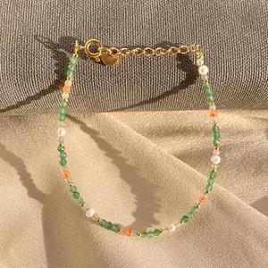 Détail des perles de cristal vert facetté et perles d'eau douce sur bracelet en or