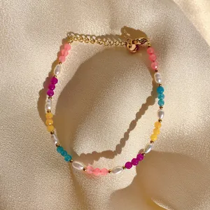 Détail de bracelet en perles colorées et perles naturelles sur fond de soie beige
