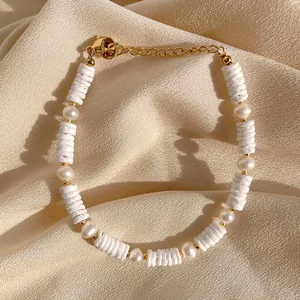 Détail de perles de nacre blanches et bracelet de perles d'eau douce sur tissu