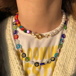 Détail du collier à deux rangs avec perles de fleurs colorées et perles d'eau douce