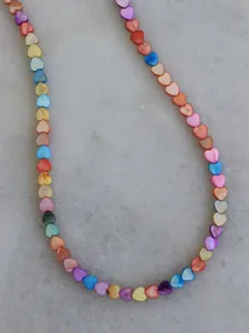 Macro view of a colorful rainbow heart necklace with pearl-like iridescent shell beads