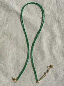 Detailed shot of green faceted stone beaded necklace with adjustable gold-tone clasp and chain