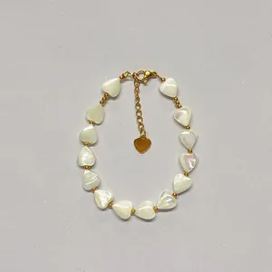 Macro shot of shell heart beads and gold spacer beads with lobster clasp and extension chain