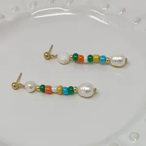 Détails de perles colorées et perles baroques blanches sur boucles d'oreilles bohèmes