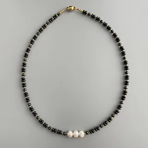 Baroque pearl necklace with black faceted beads and gold spacers in minimalist style