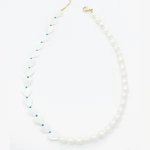 Macro detail of asymmetric handmade necklace with shell hearts and freshwater pearls