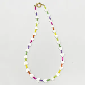 Detailed macro view of beaded necklace with shell hearts and colorful round beads
