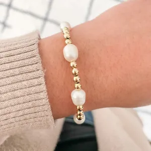Bracelet en perles d'eau douce baroques et billes en or 18k au poignet féminin