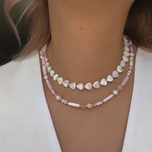 Handmade layered necklace featuring shell heart beads, irregular pearls, and gold plating
