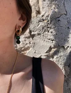 Dettaglio di orecchini a cerchio placcati oro 18k con ciondoli in pietra verde naturale