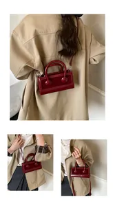 Detail view of burgundy patent leather handbag showing crossbody and handheld styles
